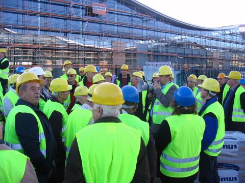 Projektmanager Thomas Glawa (Mitte, mit Mikropohon) erl&auml;utert die Messe-Baustelle.